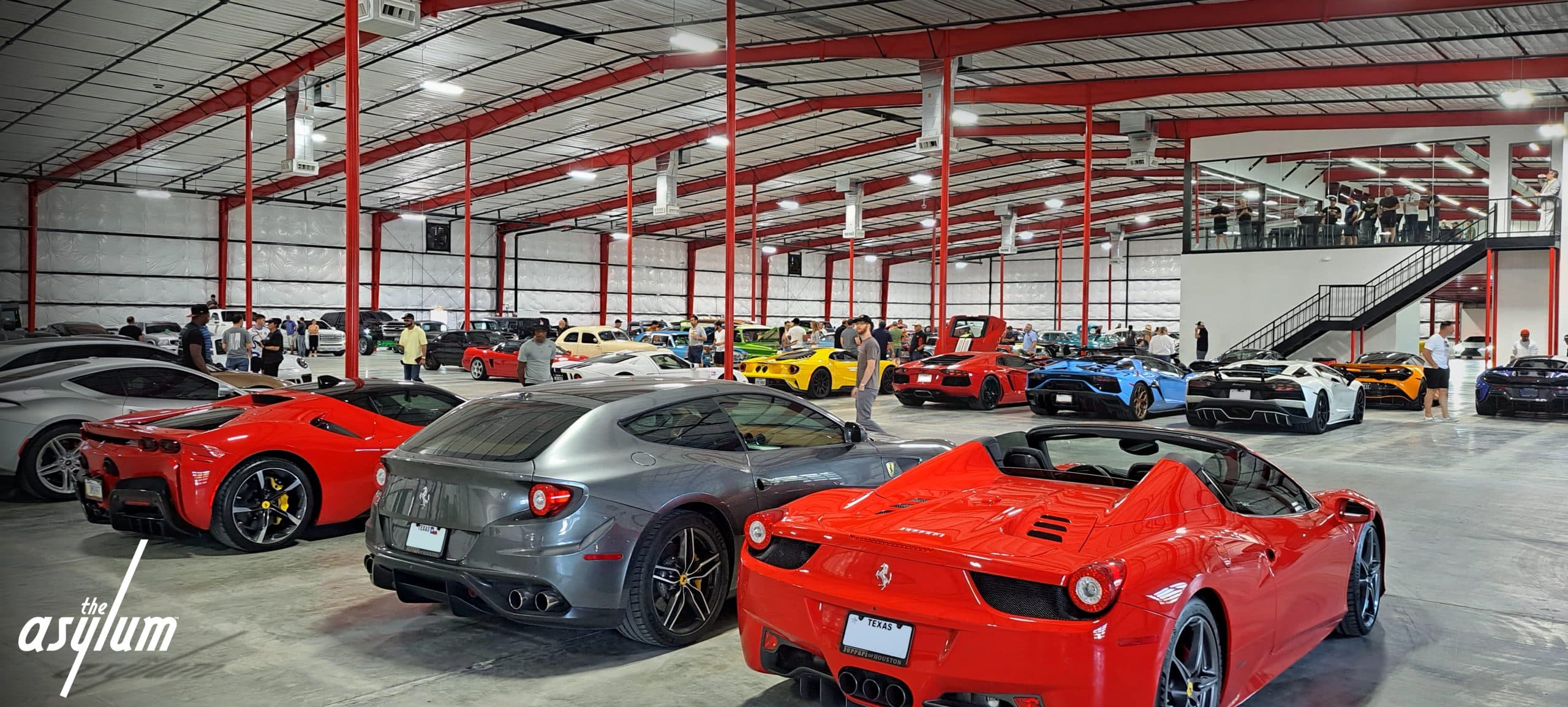 Luxury event venue at The Asylum with exotic car backdrop and guests