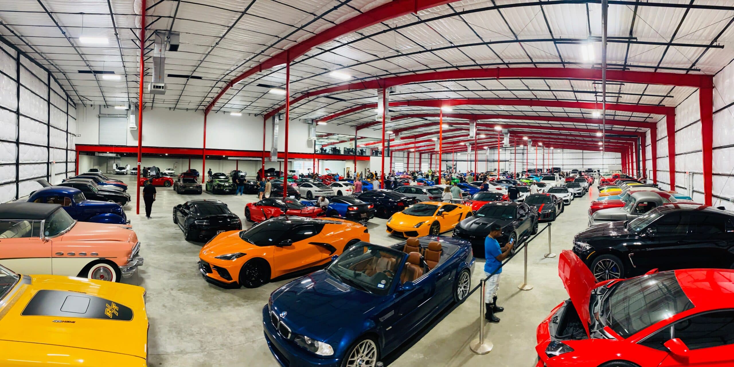 Colorful exotic cars including orange Corvette and blue BMW in The Asylum's climate-controlled storage facility