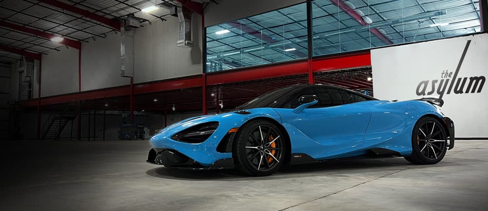 Blue McLaren supercar showcasing professional detailing results at The Asylum